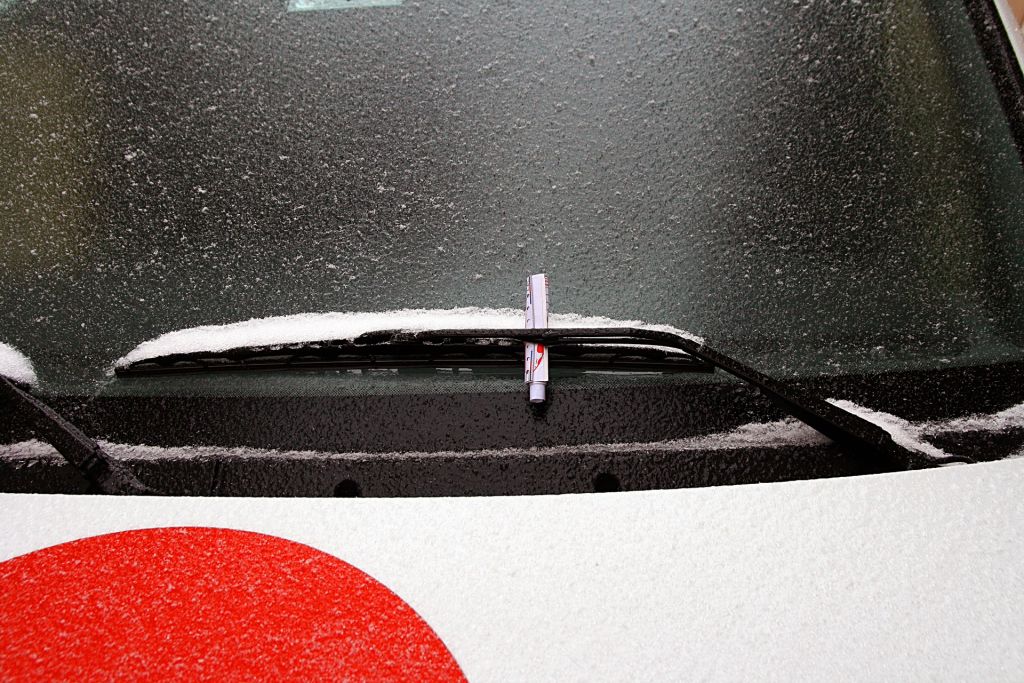 Klebezettel mit humorvoll er Aufschrift scheiße geparkt an der  Windschutzscheibe eines Falschparker